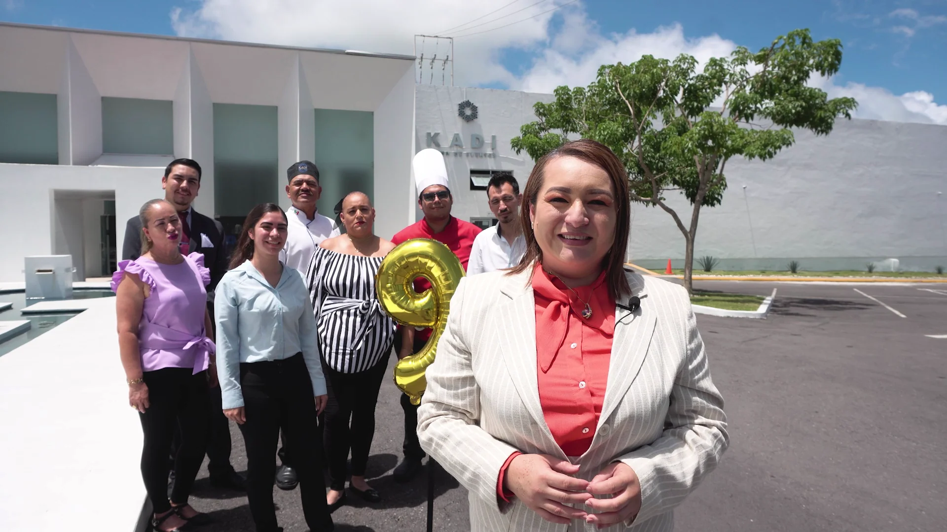 Participantes del video de aniversario de KADI frente al salón.