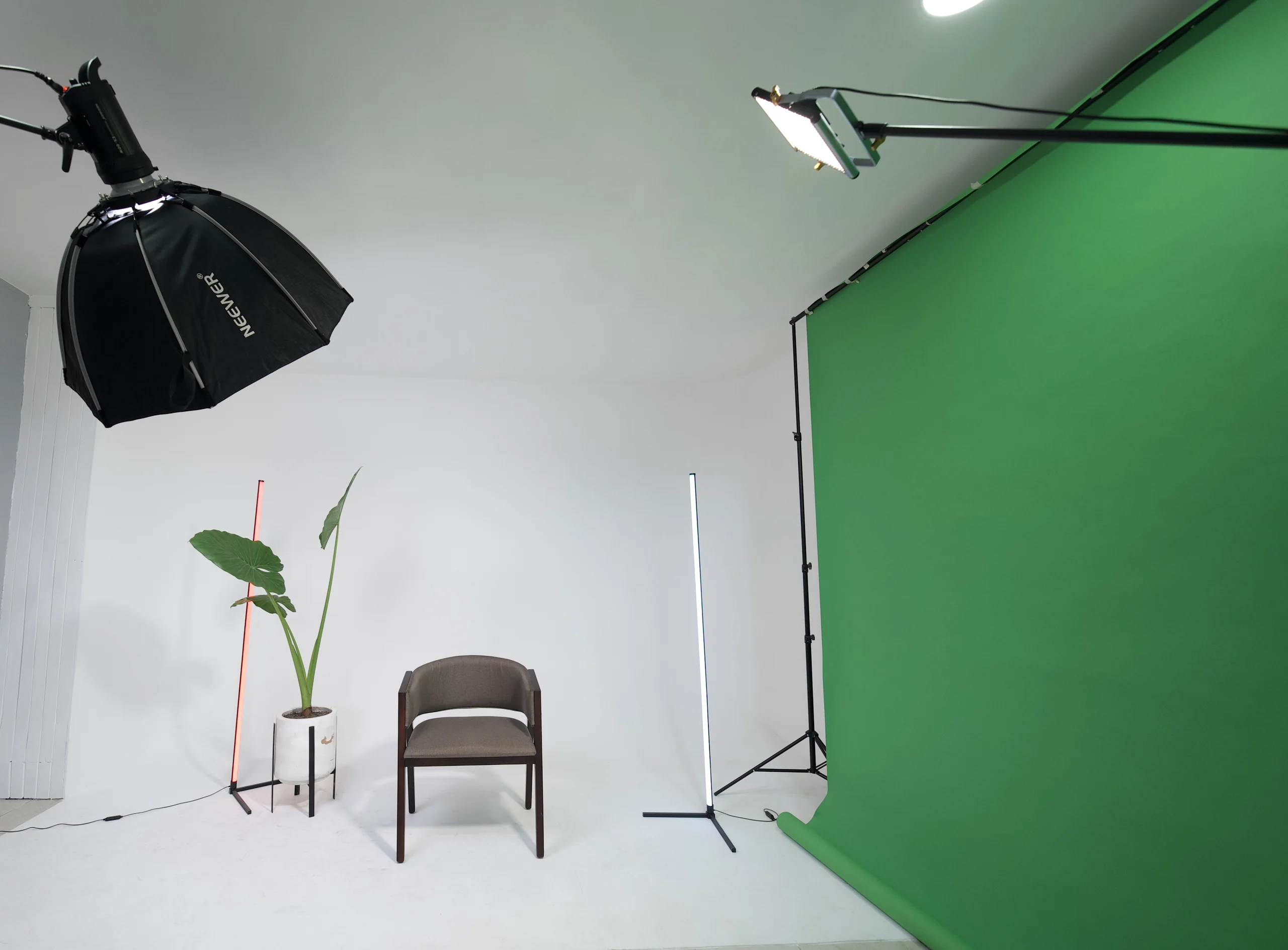 Set de foto y video de Ochenta & Ocho: ciclorama blanco con softbox, tubos de luz, una silla y un fondo verde de croma.